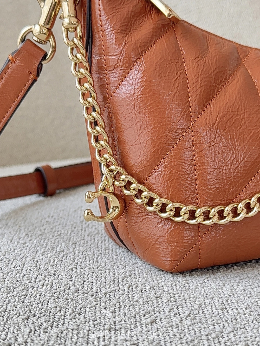 detail-charm-Coach-Caitlin-Shoulder-Bag-With-Quilting-And-Charm-Cinnamon-balilene