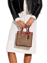 on-model-1-Coach-Field-Tote-22-In-Signature-Canvas-With-Horse-And-Carriage-Print-Tan-Truffle