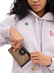 on-model-Coach-Medium-Corner-Zip-Wallet-In-Signature-Canvas-Tan-Black