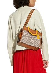 on-model-Coach-Rogue-25-In-Signature-Textile-Jacquard-Cocoa-Burnished-Amber-balilene