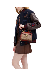 on-model-crossbody-Coach-Sammy-Top-Handle-21-In-Signature-Canvas-Tan-Rust