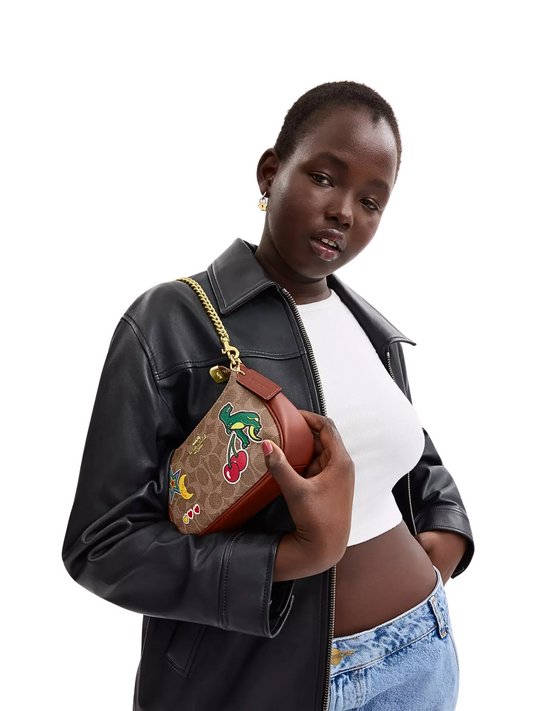 on-model-shoulder-Coach-Teri_Mini-Crossbody-Bag-In-Signature-Canvas-With-Sticker-Print-Tan-Multi