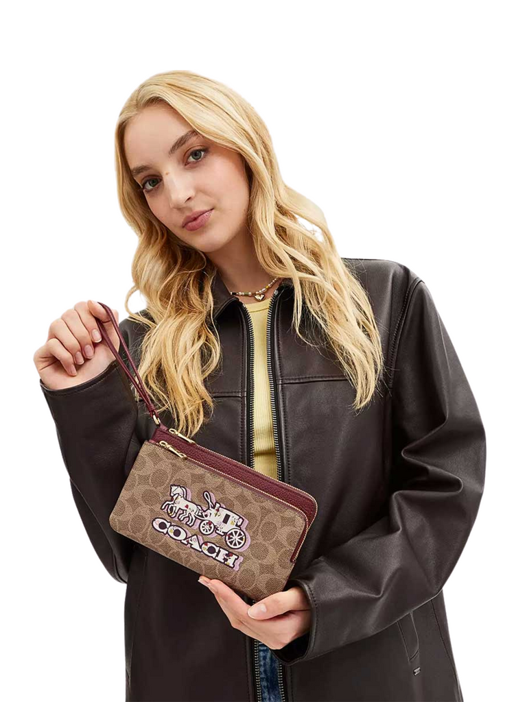 on-model-Coach-Double-Zip-Wallet-In-Signature-Canvas-With-Horse-And-Carriage-Print-Tan-Black-Cherry