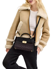 on-model-Coach-Eliza-Top-Handle-Bag-In-Signature-Canvas-Walnut-Black