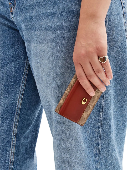 on-model-Coach-Essential-Mini-Trifold-Wallet-In-Signature-Canvas-Tan-Rust