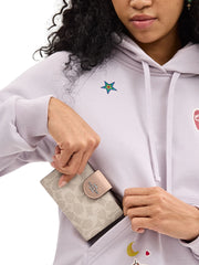 on-model-Coach-Medium-Corner-Zip-Wallet-In-Signature-Canvas-Sand-Taupe