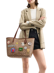 on-model-Coach-X-Peanuts-City-Tote-Bag-In-Signature-Snoopy-Patches-Tan-Brown_Multi