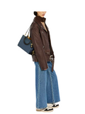 on-model-shoulder-Coach-Rogue-Bag-25-In-Regenerative-Leather-Dark-Denim-Multi