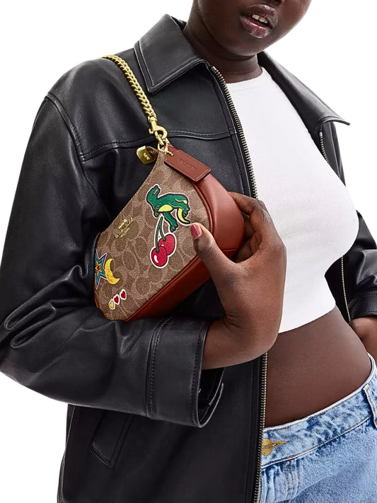 on-model-shoulder-Coach-Teri-Mini-Crossbody-Bag-In-Signature-Canvas-With-Sticker-Print-Tan-Multi