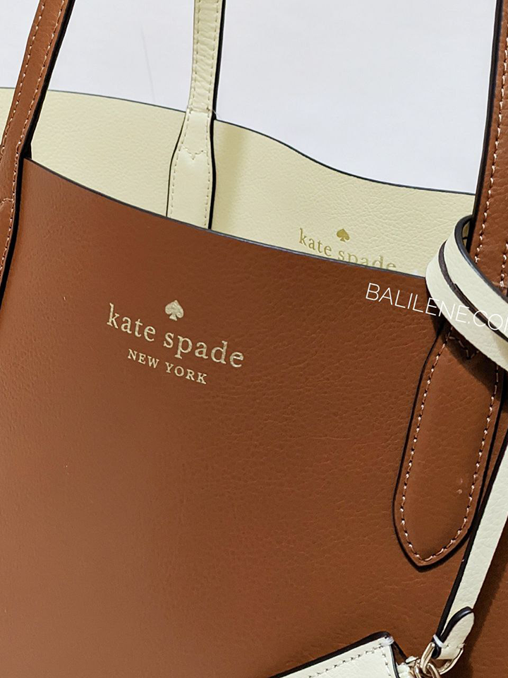    Kate-Spade-Ava-Reversible-Tote-Refined-Grain-Warm-Gingerbread-Crisp-Peac-Balilene-detail-logo